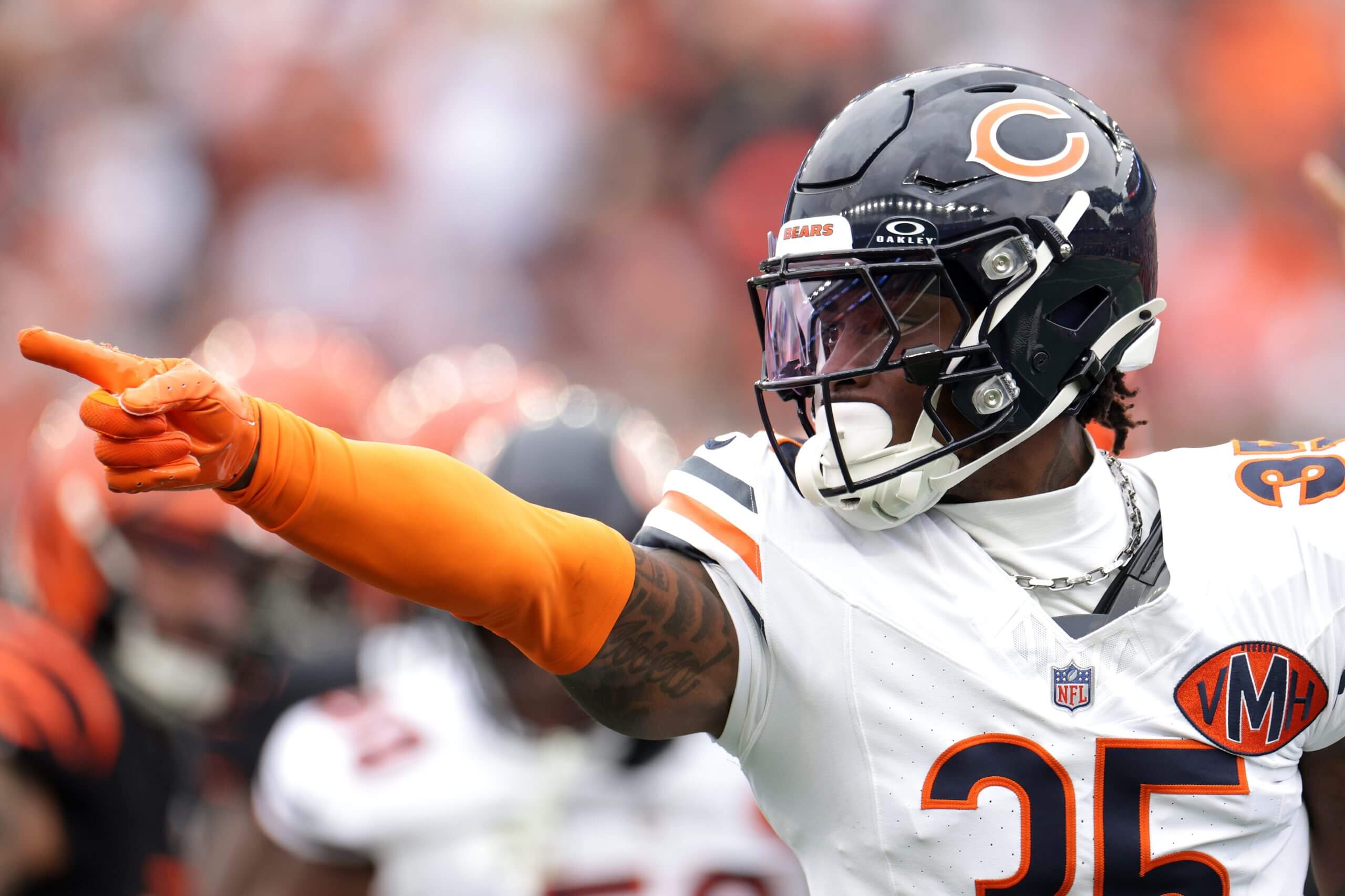 C.J. Gardner-Johnson #35 of the Chicago Bears points with his orange-gloved hand toward the right.