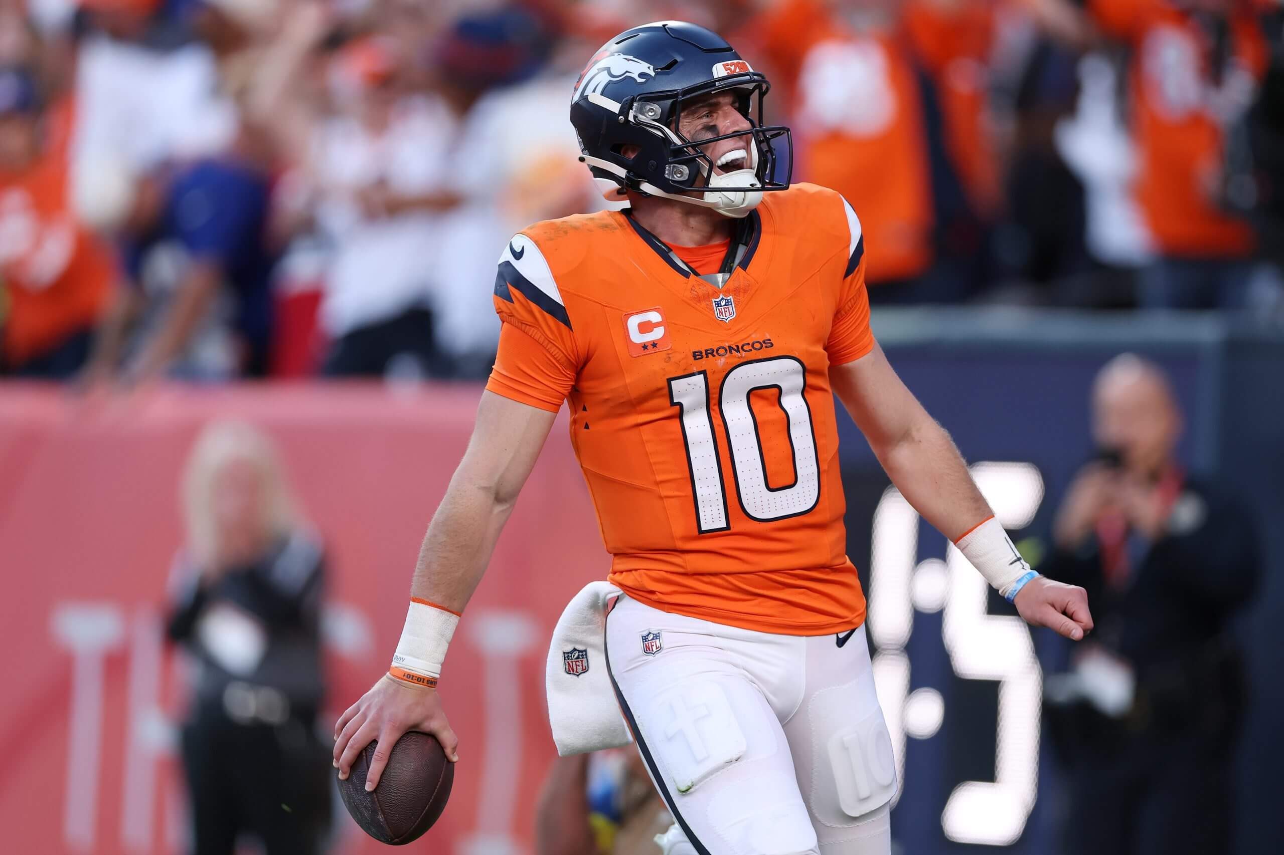 Broncos quarterback Bo Nix holds the football in his right hand as he celebrates one of his rushing touchdowns Sunday against the Giants.