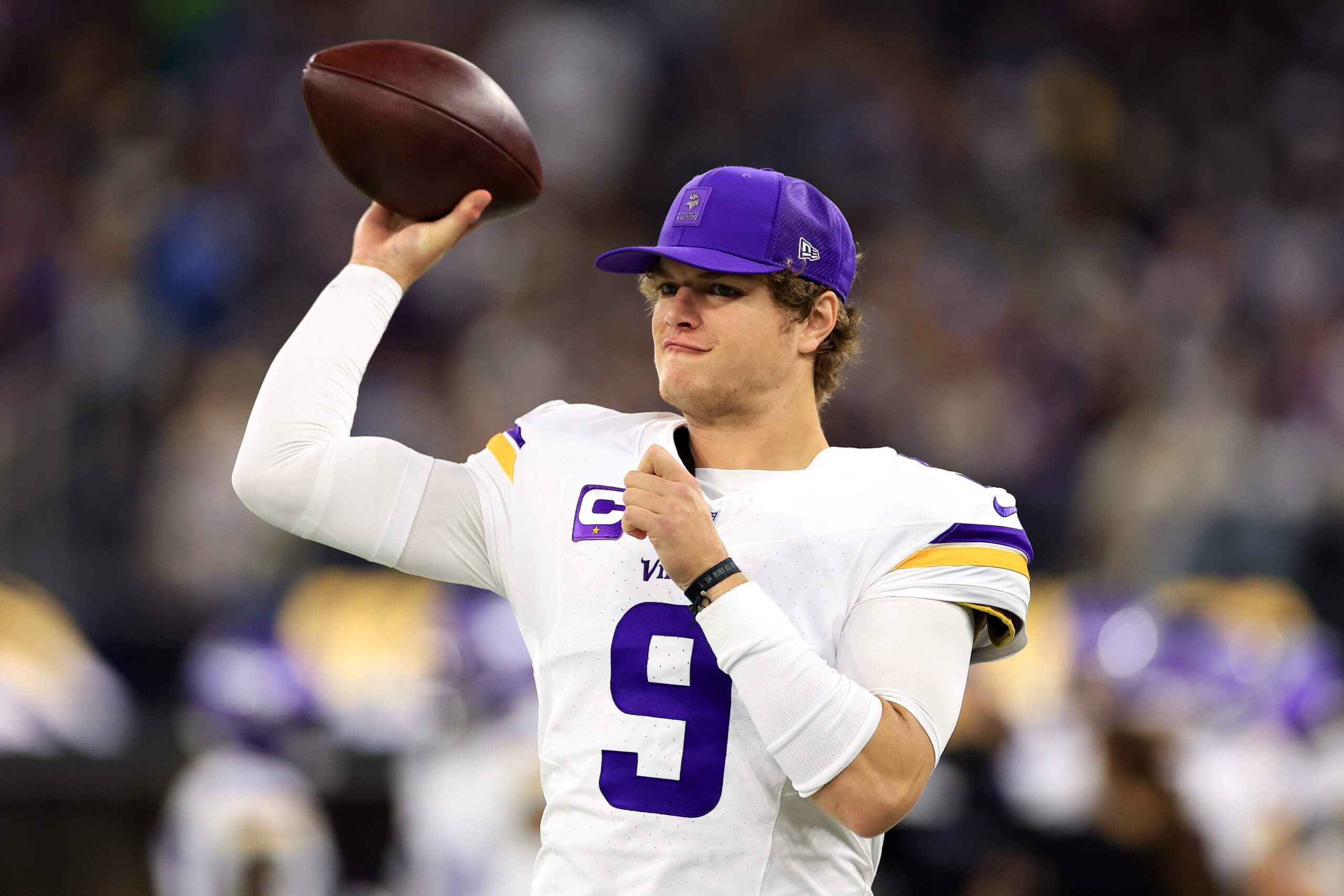 Minnesota Vikings QB J.J. McCarthy, wearing a white No. 9 jersey, prepares to throw a football.