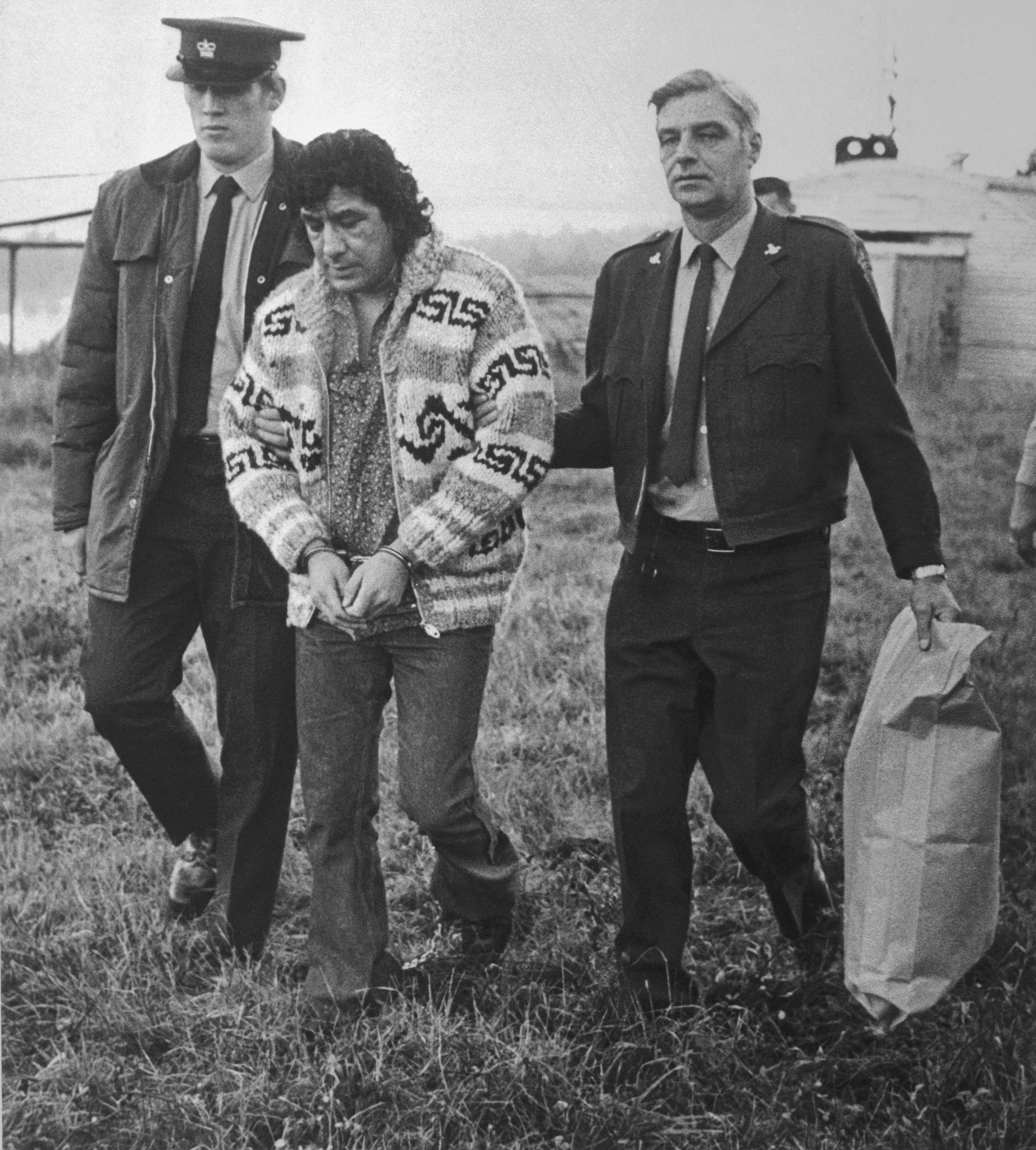 Leonard Peltier, American Indian Movement leader, is led across Okalla prison exercise yard to a waiting helicopter. 