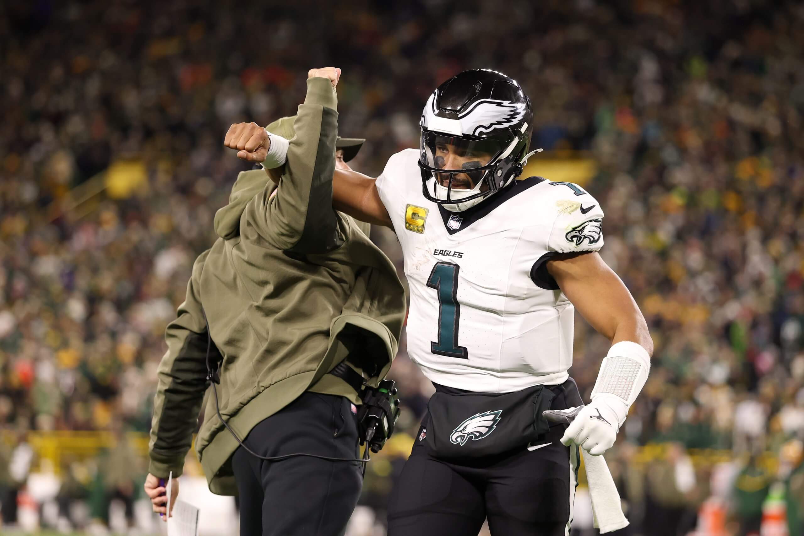 Jalen Hurts, No. 1 of the Philadelphia Eagles, celebrates a touchdown by jumping and locking arms with coach Nick Sirriani. Jalen Hurts, No. 1 of the Philadelphia Eagles, celebrates a touchdown by jumping and locking arms with coach Nick Sirriani.